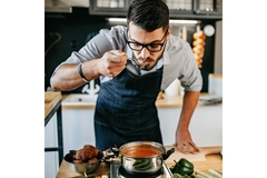 Image male chef tasting soup in a hipster wooden kitchen